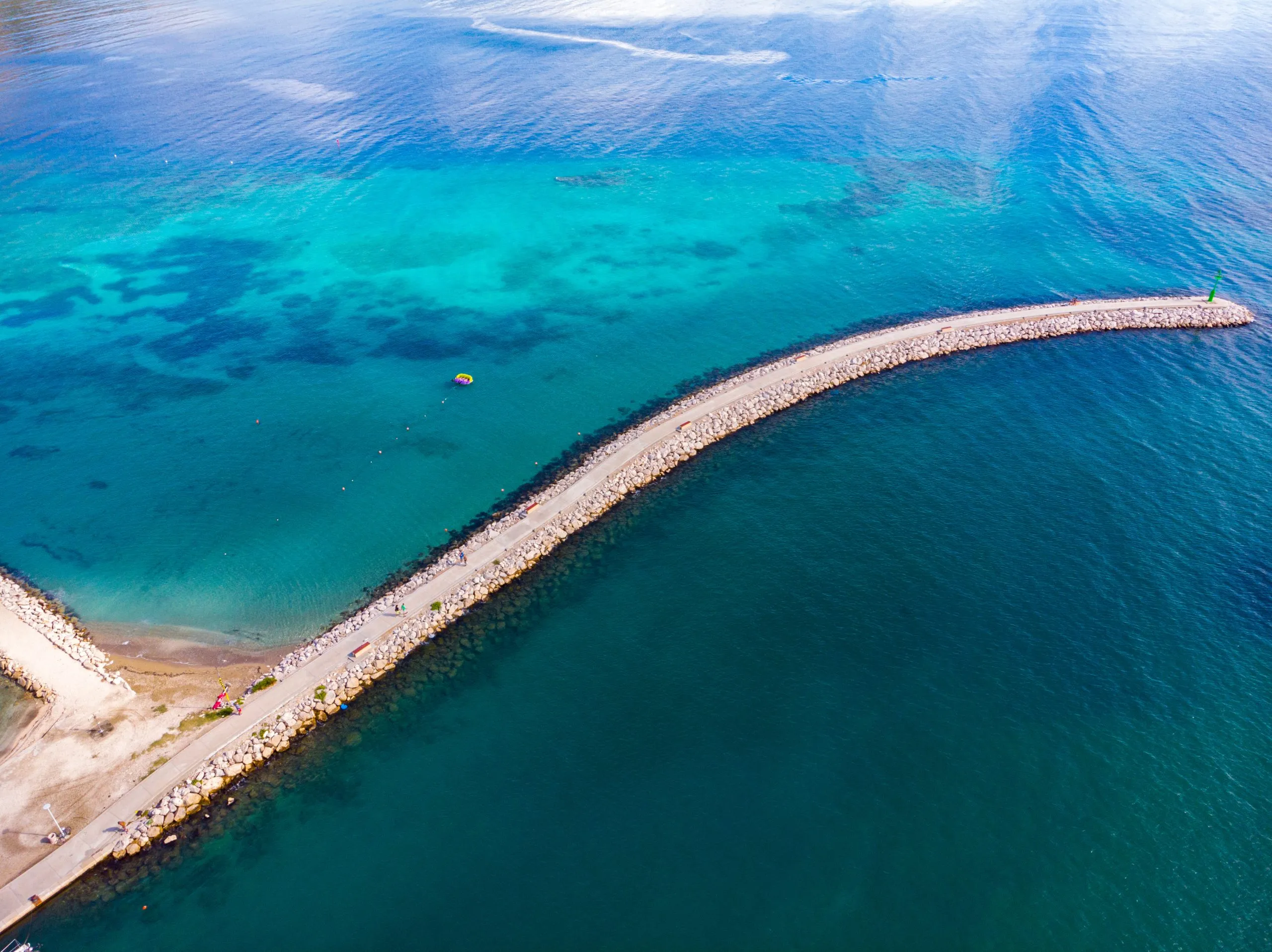 aerial view of the town of omiš in croatia, a picturesque town on the adriatic coast with the mouth of the cetina river, a beautiful beach and mighty mountains in the background as seen from a drone