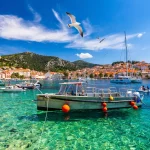 Die Stadt Hvar mit Möwen, die über die Stadt fliegen, ein berühmtes Luxusreiseziel in Kroatien. Boote auf der Insel Hvar, eine der vielen Inseln in der Nähe von Dubrovnik und Korcula an der dalmatinischen Küste Kroatiens.