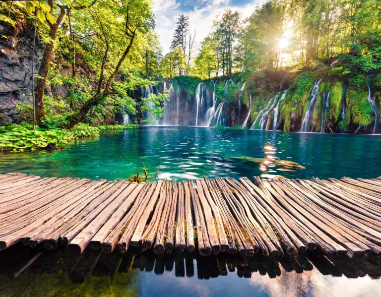 Pittoresk ochtendzicht van Plitvice Nationaal Park. Kleurrijke lentescène van groen bos met zuivere waterval. Groot plattelandslandschap van Kroatië, Europa.