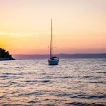 Segelboot beim Einlaufen in den Hafen von Vela Luka während des Sonnenuntergangs auf der Insel Korčula in Kroatien.