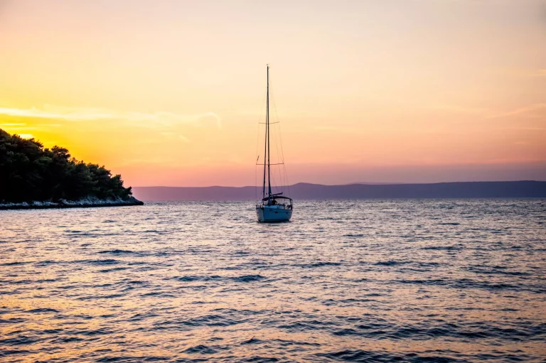 Sailboat coming in to Vela Luka harbor during the sunset on the island of Korčula in Croatia.